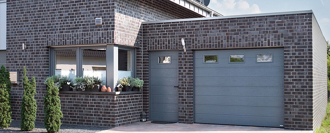 Sectional garage door with matching side door and window in pigeon blue